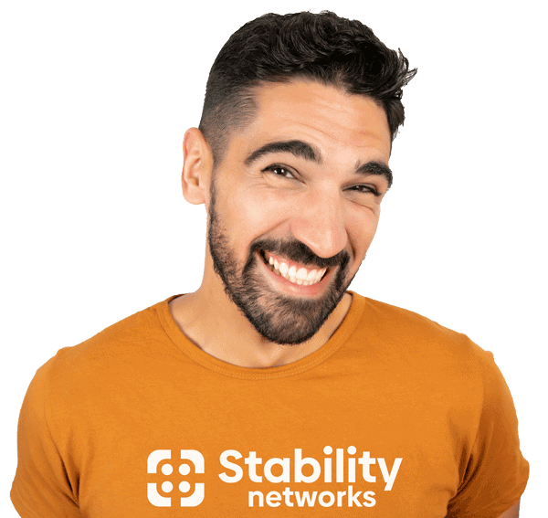 A man wearing an orange t-shirt with the words "Stability Networks" on it providing IT support services.
