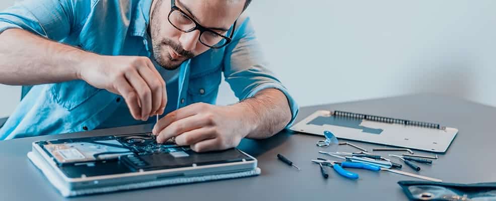 Man working on laptop by disassembling it